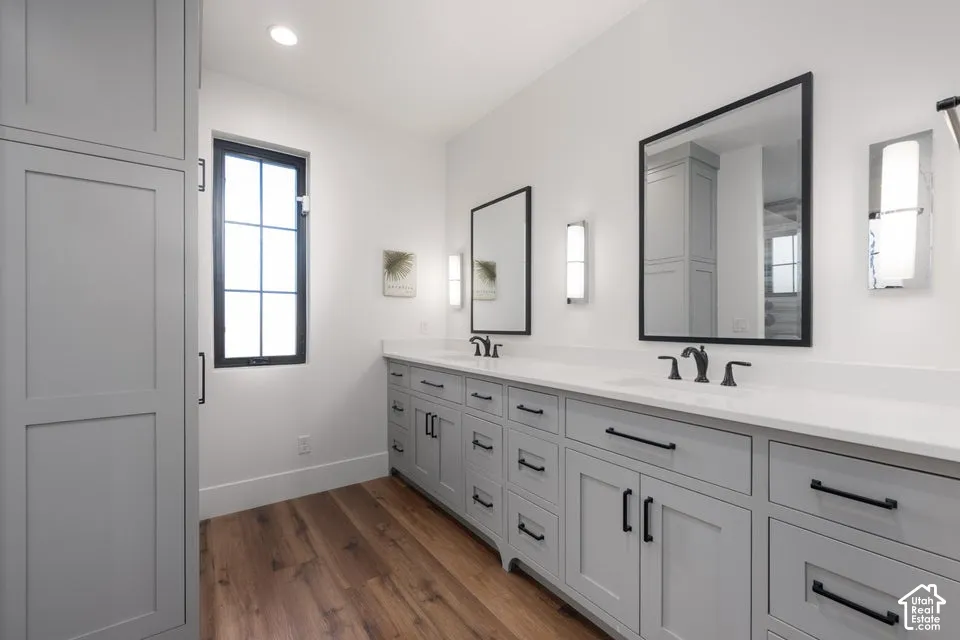 Dual vanity with light gray cabinetry, matte black hardware, and white countertops