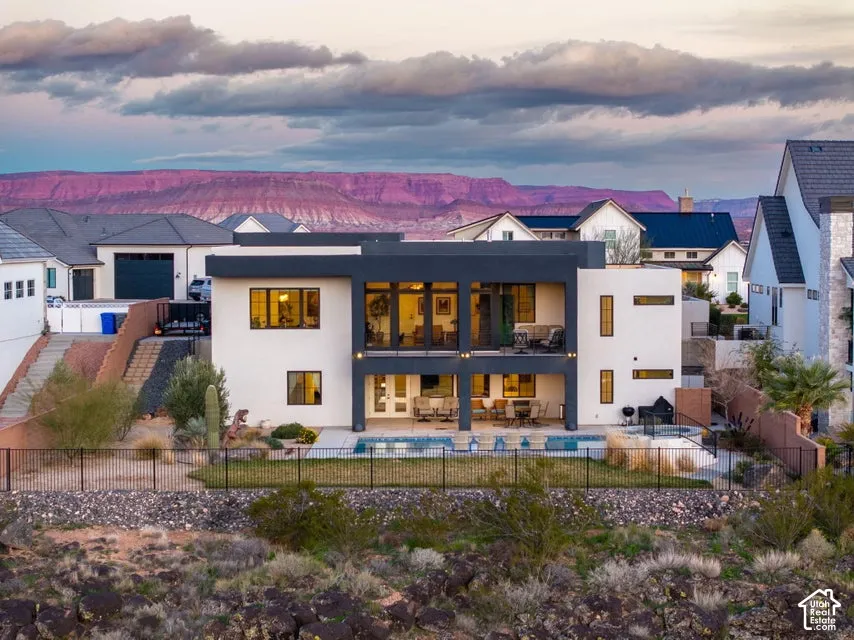 Modern exterior architecture featuring a swimming pool, integrated spa, and an upper-level balcony