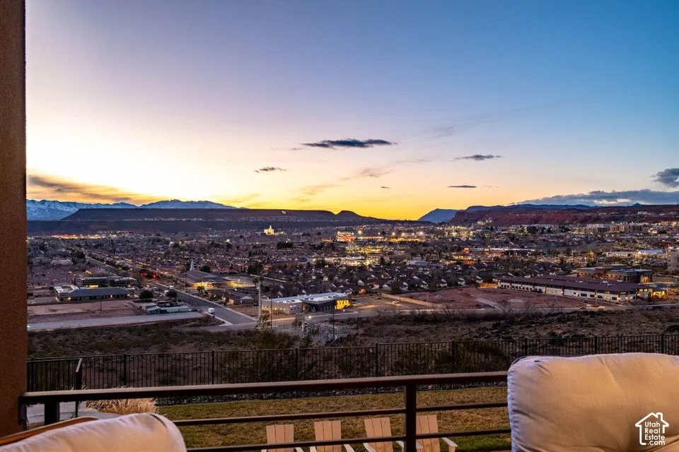 Panoramic sunset vistas overlooking the city skyline from an expansive covered balcony with metal railings