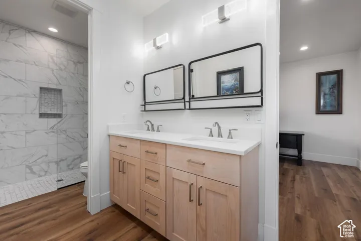 Dual vanity with light wood cabinetry, white countertop, and contemporary black-framed mirrors