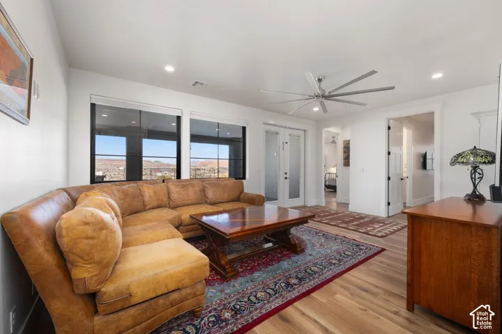 Spacious living area featuring large windows, wood-finish flooring, recessed lighting, and a ceiling fan