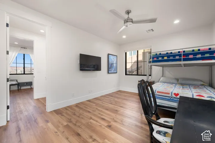 Wood-finish flooring throughout, recessed lighting, ceiling fan, and a built-in wall-mounted television