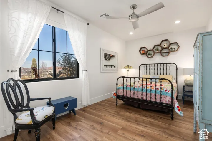 Wood-finish flooring, recessed lighting, and a contemporary ceiling fan