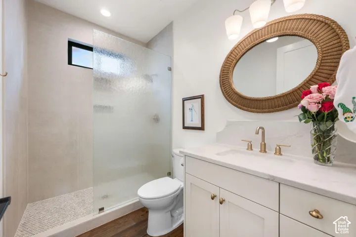 White vanity with a single basin sink, brass-finish faucet, and coordinating hardware