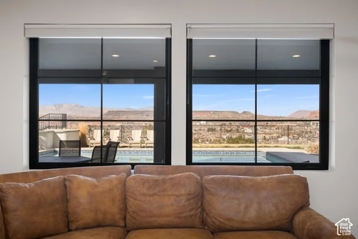 Dual large picture windows with black frames, showcasing a swimming pool and distant mountains