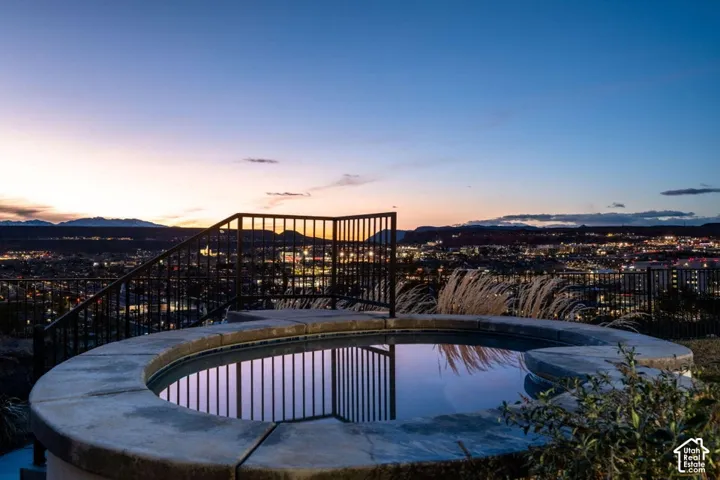 Circular hot tub with stone coping and black metal railing