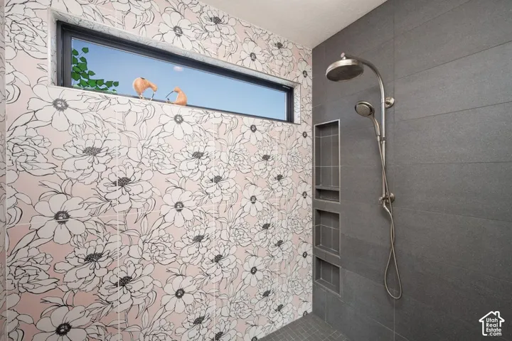 Shower featuring a rainfall showerhead, handheld shower fixture, and three recessed niches