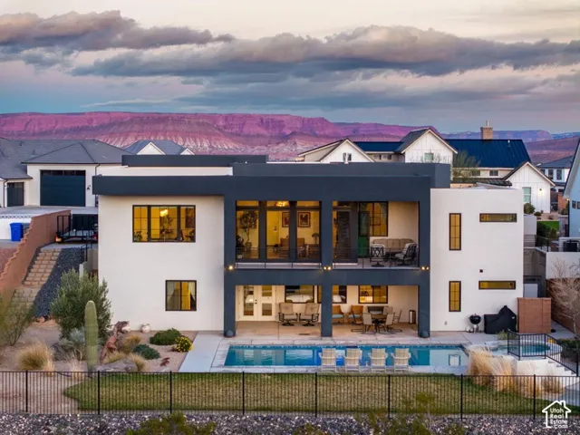 Modern architectural design featuring expansive windows, an outdoor swimming pool, and a dedicated outdoor patio space