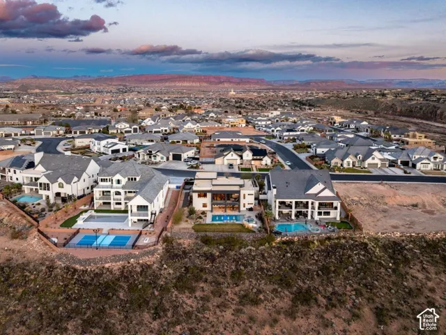 Expansive residential development featuring multiple properties, mature landscaping, and an outdoor recreational court
