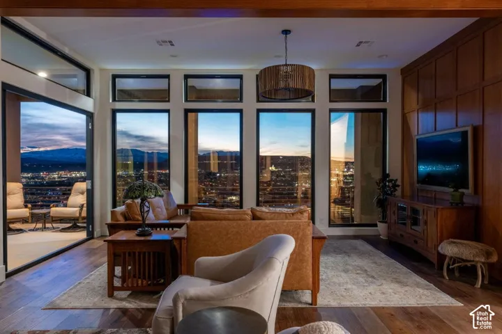 Expansive living area with large windows, wood-finish flooring, and built-in wood paneling