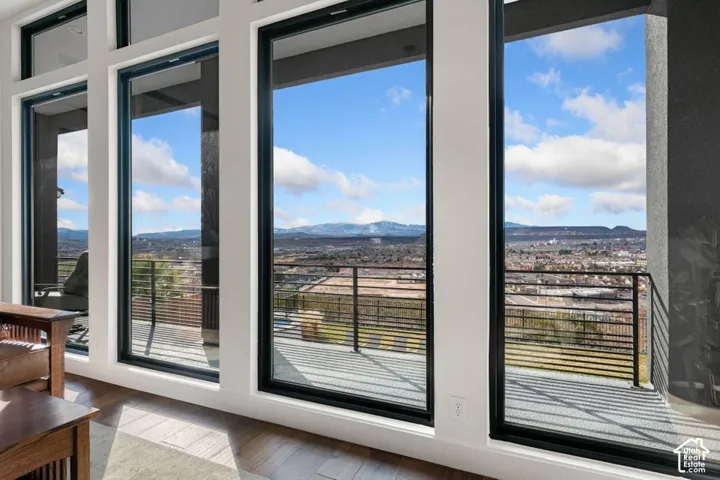 Full-height windows with dark frames, leading to an outdoor balcony
