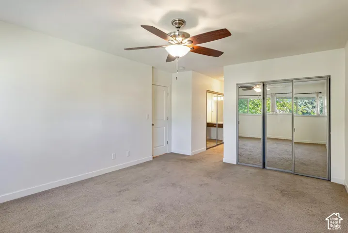 Recessed lighting, wood-finish ceiling fan, mirrored closet doors, carpeted flooring, and a vanity area