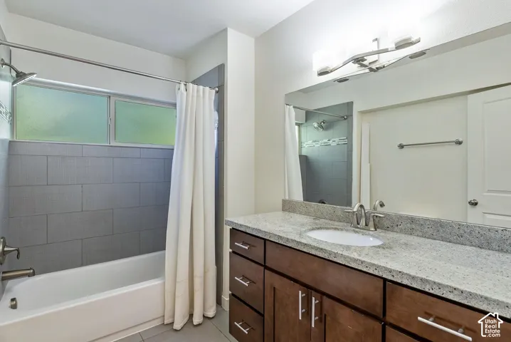Vanity with a light-colored countertop, undermount sink, and wood-finish cabinetry