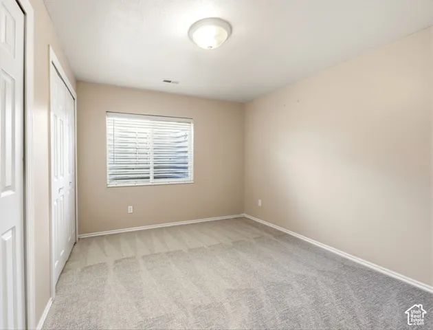 Neutral-toned walls complement the light-colored carpet flooring