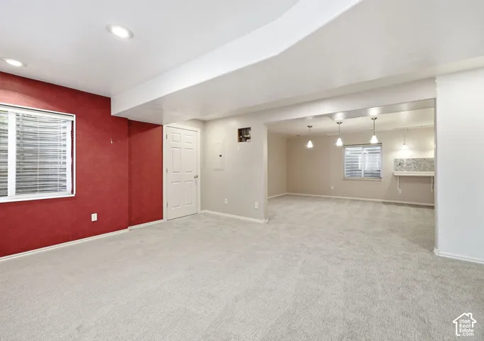 Expansive room featuring recessed lighting, light-toned carpeting, and a built-in shelf with a tiled backsplash
