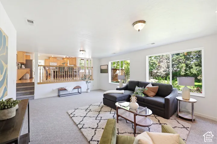 Carpeted living area with white walls and recessed lighting