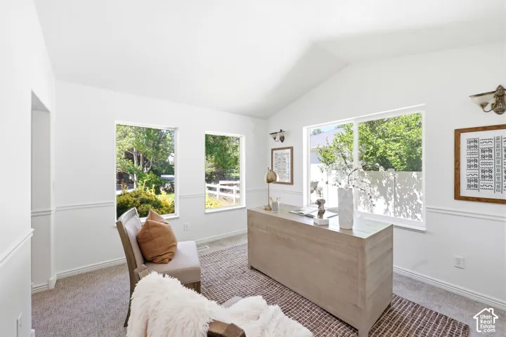 Vaulted ceiling, multiple windows, picture frame molding, wall-mounted sconces, carpeted flooring