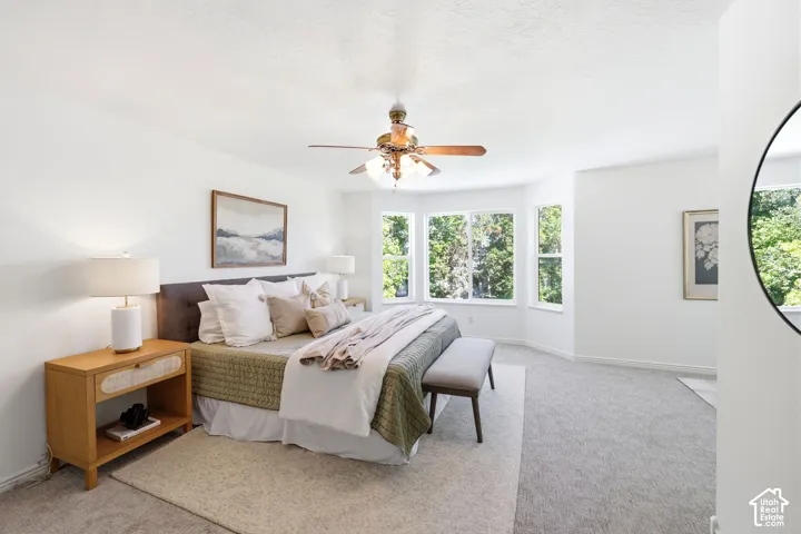 Recessed bay windows, ceiling fan, and light gray carpeting