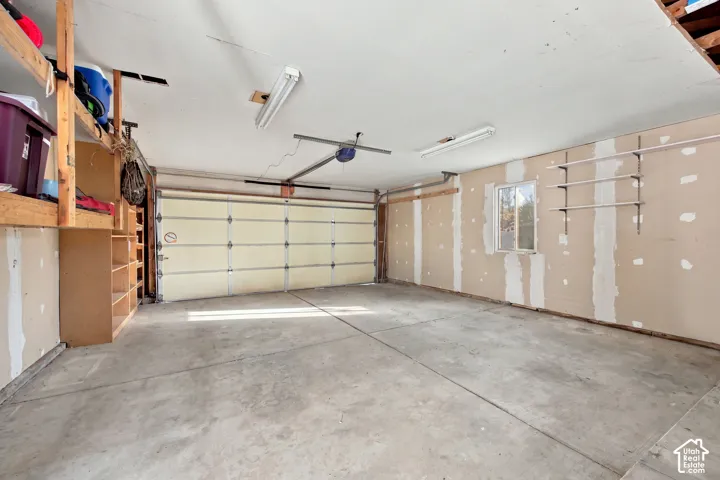 Concrete flooring, built-in shelving, fluorescent lighting, and a single window