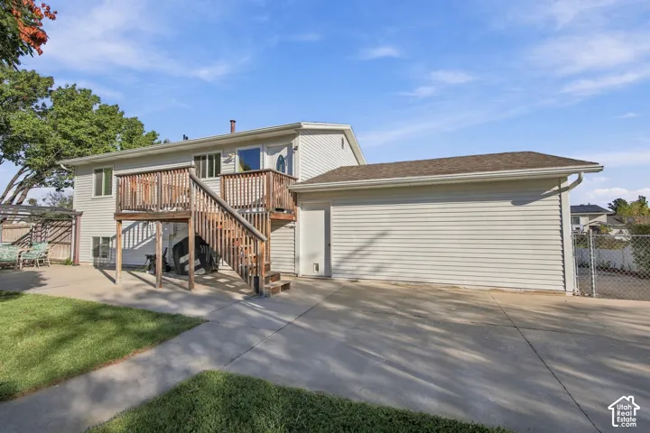 Multi-level wood deck with stairs, extending to a concrete patio
