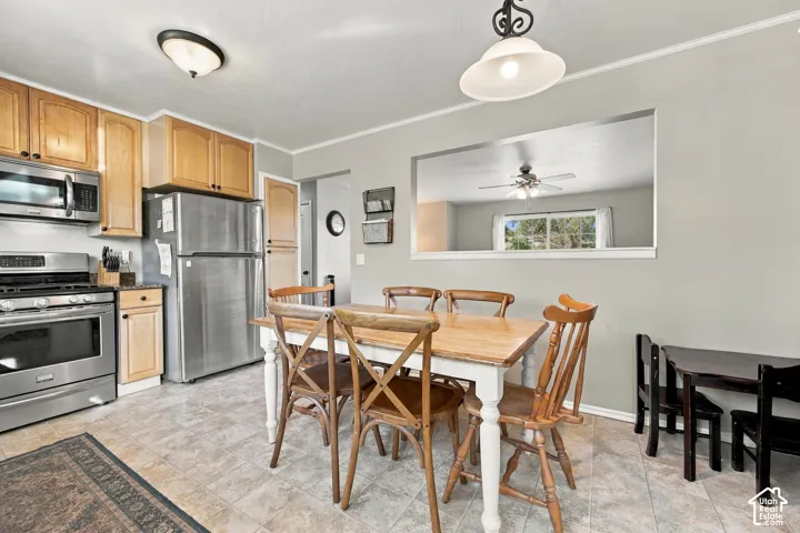Stainless steel appliances, wood-finish cabinetry, neutral wall paint, and overhead lighting