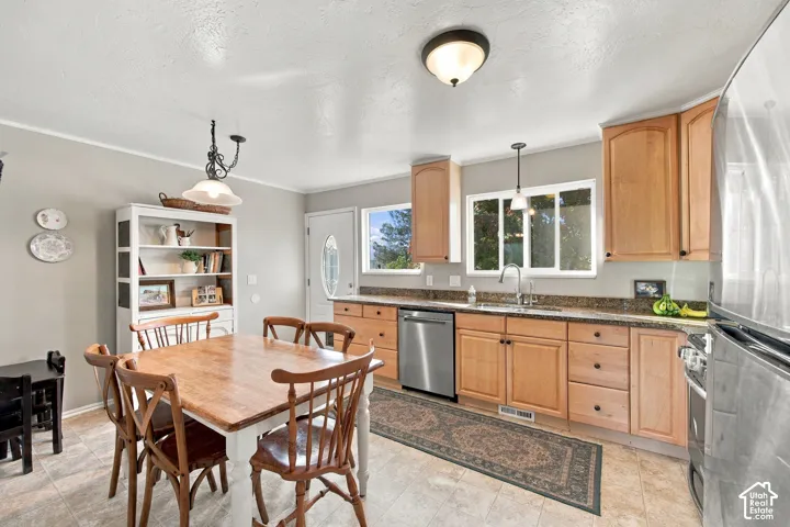 Light wood-finish cabinetry, stainless steel appliances, and a built-in kitchen sink with a window