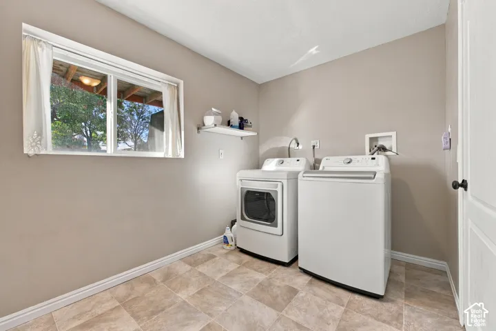 Laundry area featuring a window, tile flooring, and a wall-mounted shelf