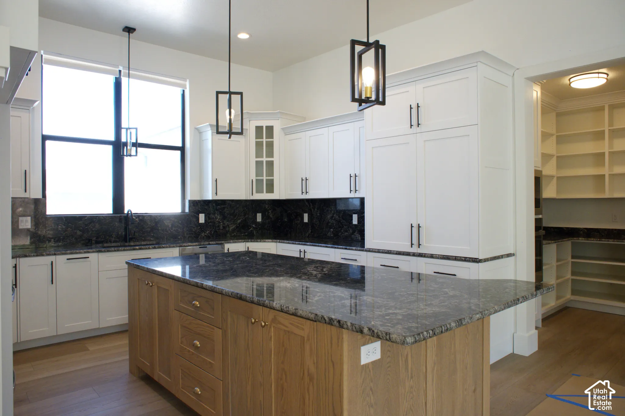 White shaker cabinetry with dark stone countertops and backsplash