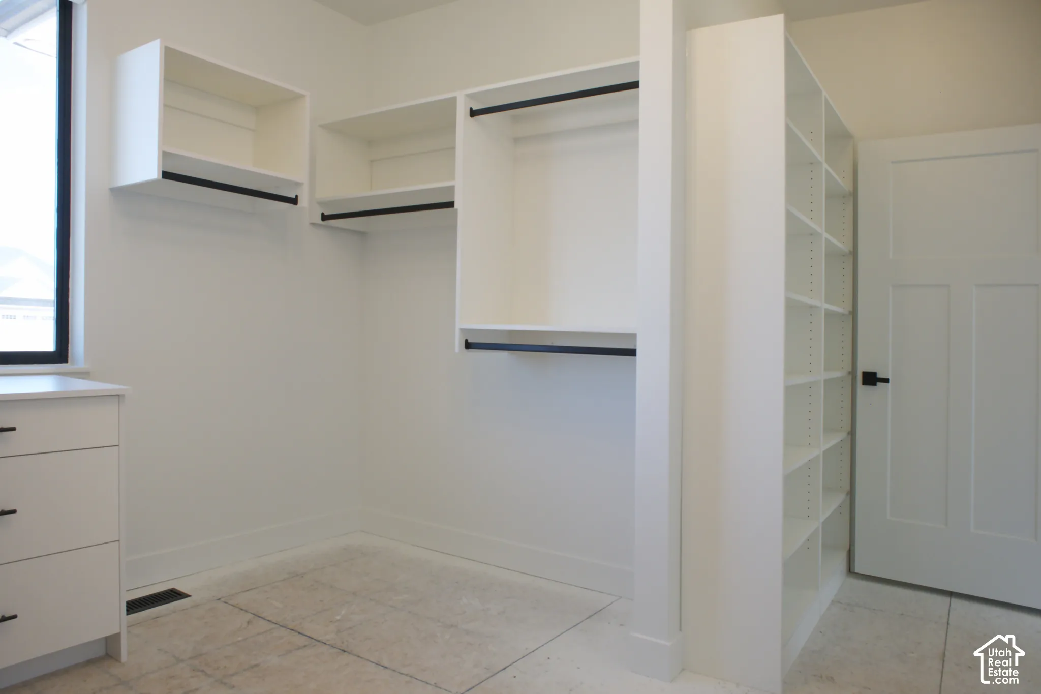 Custom built-in closet system featuring white cabinetry, storage shelving, and hanging rods