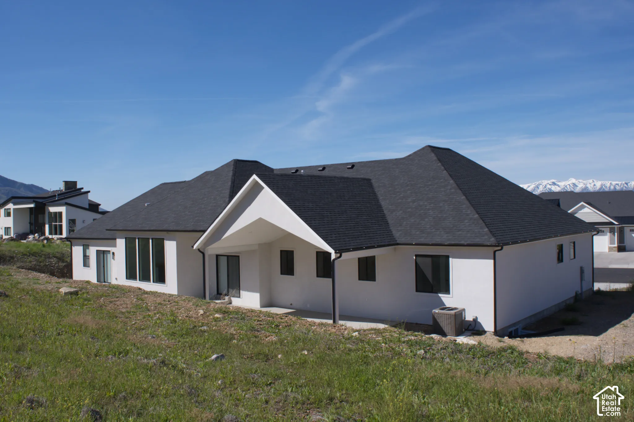 White stucco exterior with a dark asphalt shingle roof