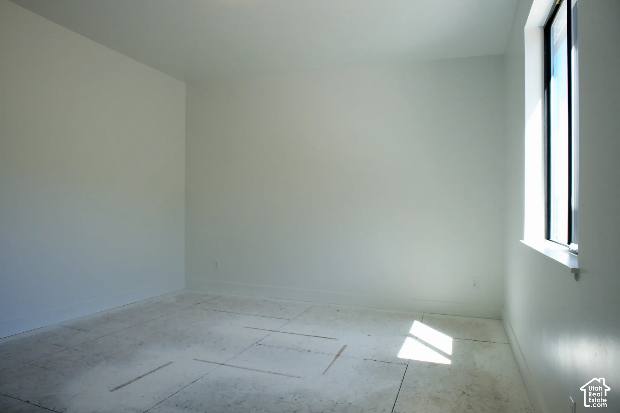 Light-filled interior space featuring neutral wall tones and a single-pane window
