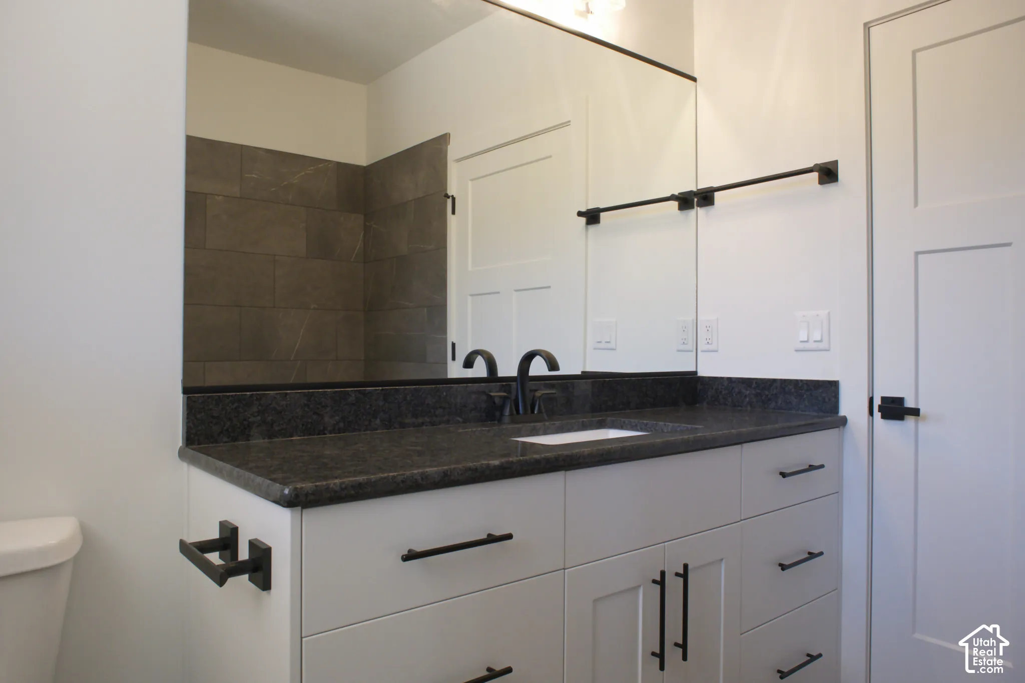 White vanity with black countertop and integrated sink