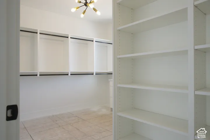 Integrated closet system featuring white shelving, black hanging rods, and a Sputnik-style ceiling light
