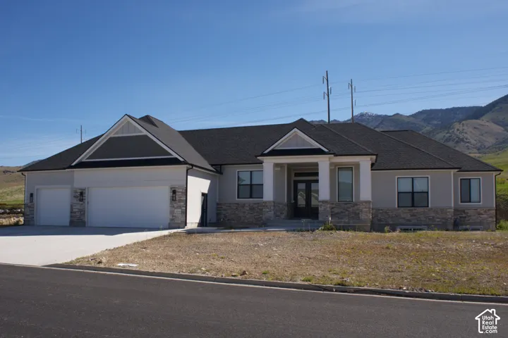 Stone and siding exterior with a dark shingle roof
