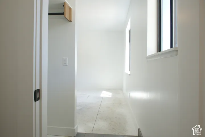 Bright interior with white walls, multiple windows, and a built-in closet rod