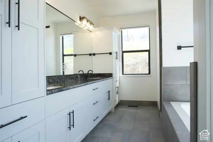 Dual vanity with dark stone-finish countertop, undermount sinks, and matte black fixtures