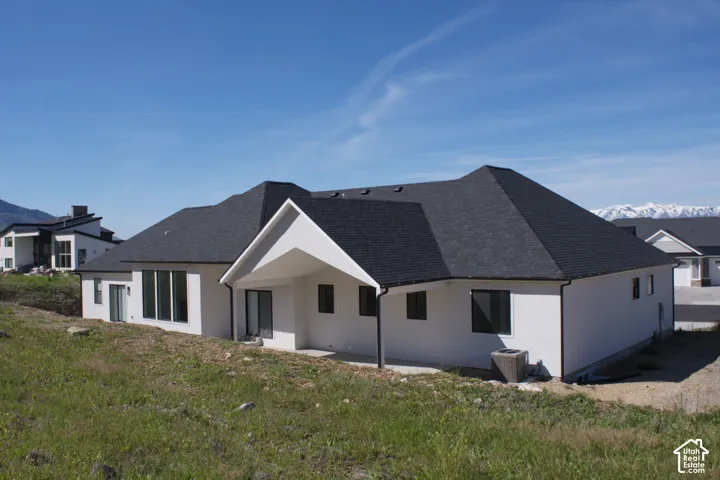 White stucco exterior with a dark asphalt shingle roof