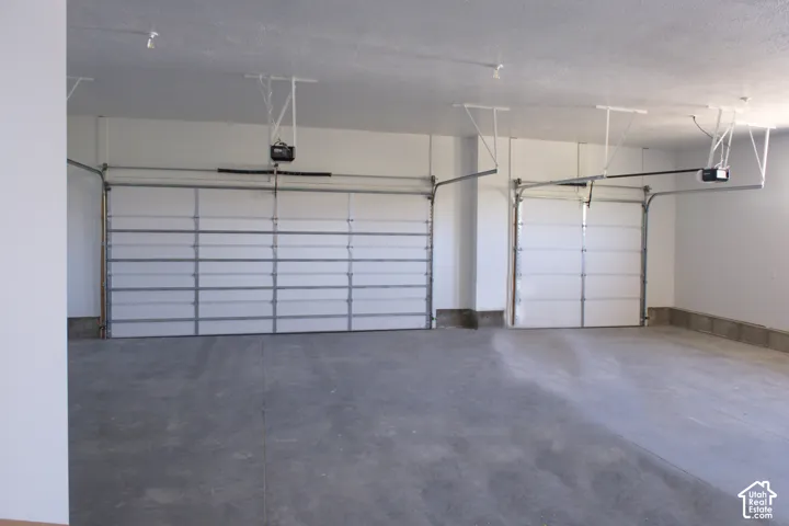 Attached two-car garage featuring segmented overhead doors and automatic openers