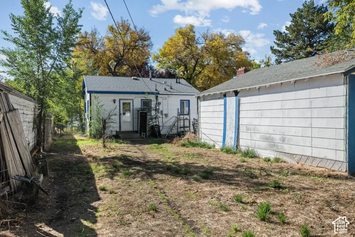 Exterior grounds featuring a detached structure, white siding, and mature trees