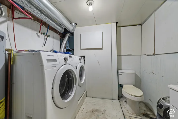 Utility area featuring a two-piece toilet, built-in cabinetry, and laundry hookups