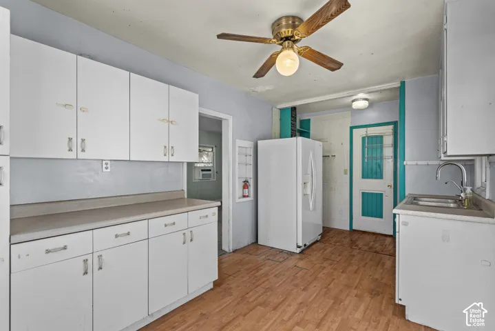 Kitchen featuring white cabinetry, wood-finish flooring, a stainless steel sink with a goose-neck faucet, and a ceiling-mounted light fixture
