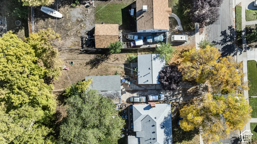 Aerial perspective featuring a detached garage, concrete driveway, and mature landscaping