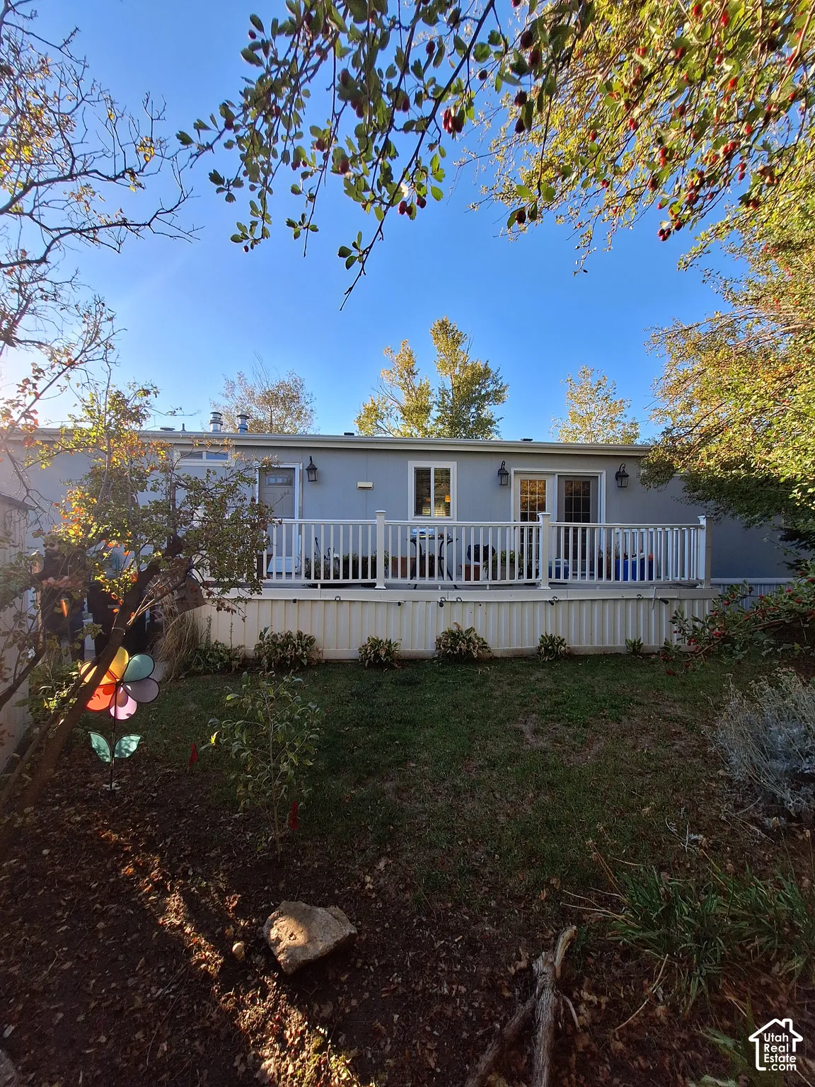 Rear exterior with a spacious deck, white railing, and dual sliding glass doors