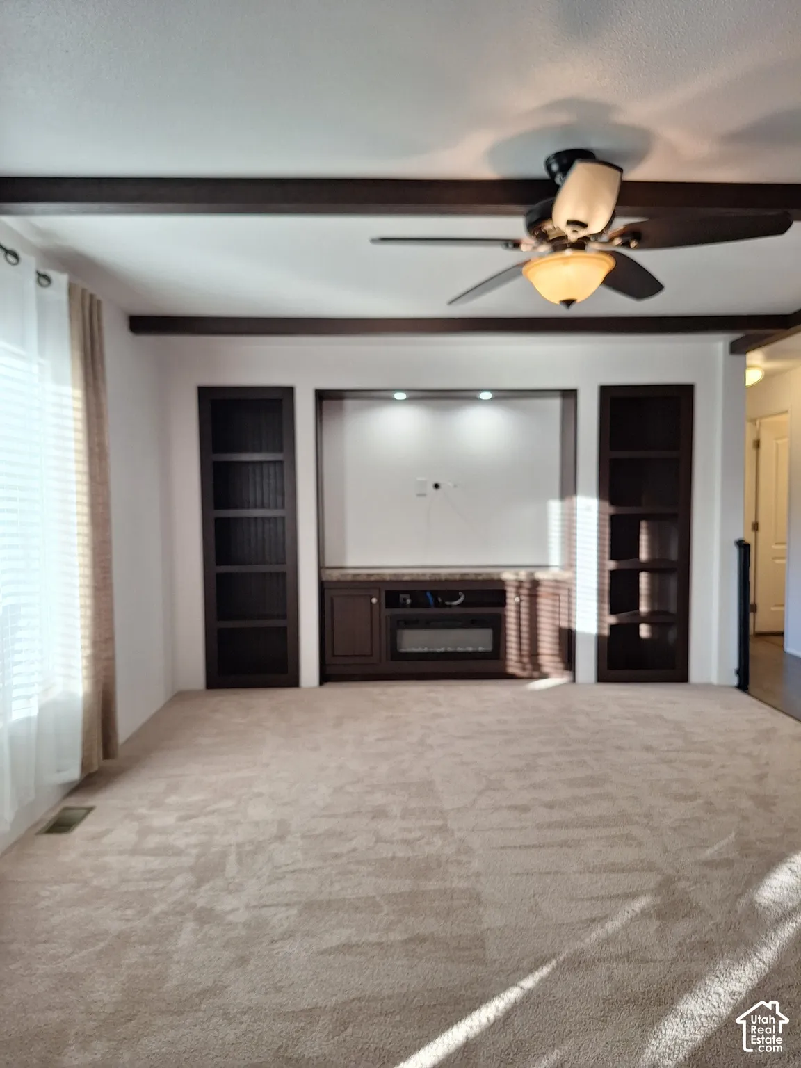 Built-in entertainment center with integrated shelving, recessed lighting, and an electric fireplace