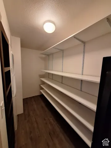 Recessed ceiling lighting, wood-finish flooring, and multiple white shelving units