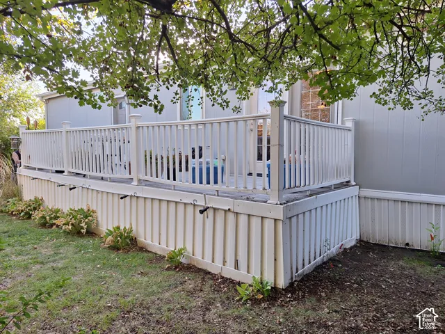 White deck with baluster railing, privacy skirt, and ground-level landscaping