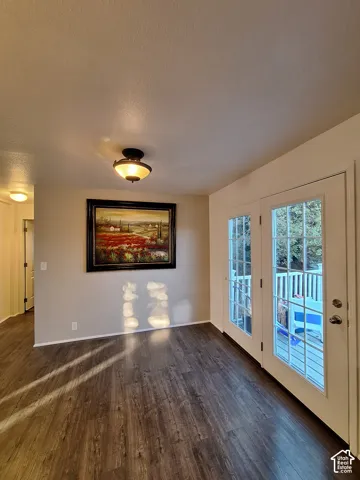 Wide plank wood-finish flooring, recessed lighting, and wall-mounted light fixtures