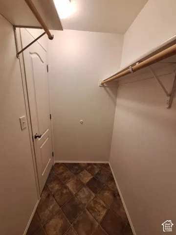 Tiled flooring, built-in shelving, and hanging rods