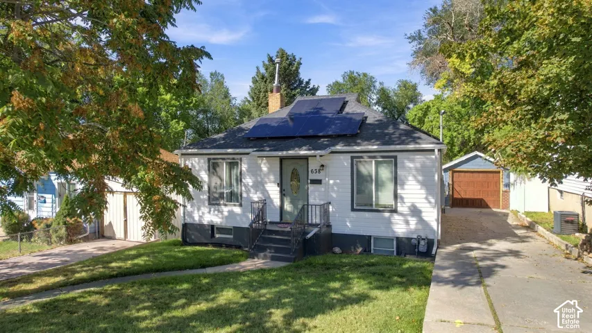 White siding exterior with a dark roof and solar panels