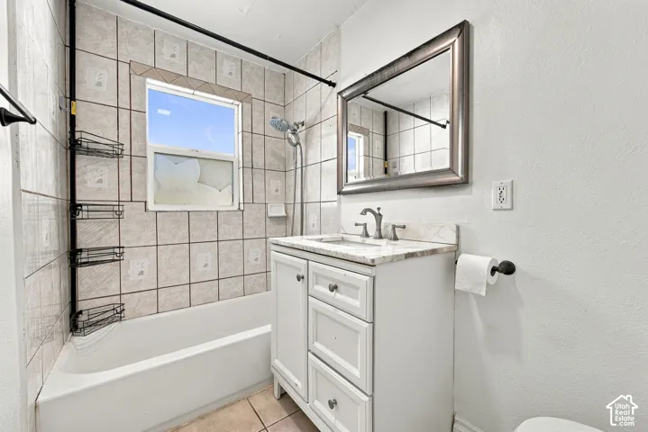 White vanity with paneled doors and drawers, a light-toned countertop, and a framed mirror
